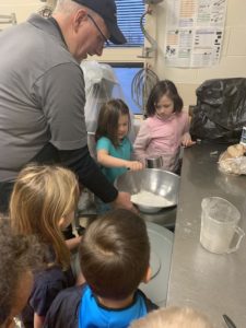 Kindergarten and first grade students cooking with Richard Johnson, Kurn Hattin’s food services manager 