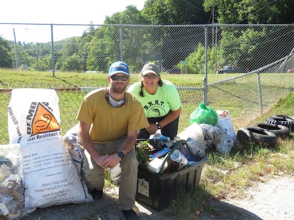 Steve and Maura Anderson with a tub of trash they collected from the lowest mile of the Black River