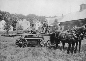 Ed Spaulding at Cobleigh Field with Yo-Semite hand-pumper. Wiggins barn can be seen on the right circa 1923. Photo provided by Ted Spaulding