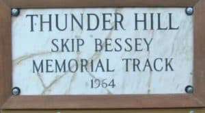 Wood and marble plaque reads "Thunder Hill Skip Bessey Memorial Track 1964"