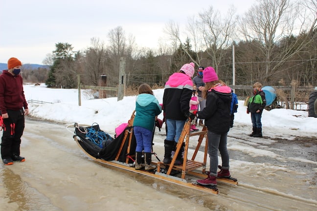 Children taking a turn on the dog sled