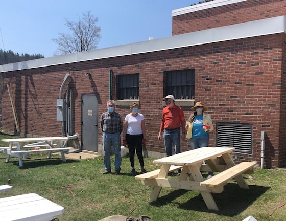 Volunteers David Foster, OVRCC's Carol Lighthall, Holger Stoltze and Susan Damone Balch of Fletcher Farms sand and prime picnic tables for The Gathering Place
