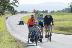 A handcyclist and cyclists along the course in the 14th annual Kelly Brush Ride powered by VBT Bicycling Vacations, Sept. 7, 2019. The annual ride, which was held virtually in 2020 due to the COVID-19 pandemic, returns on September, 11, 2021, to Middlebury, Vermont. In 2019 the ride drew 940 cyclists and 27 handcyclists from 20 states. The event raised more than $700,000 for adaptive sports and ski racing safety. Photo provided by the Kelly Brush Foundation