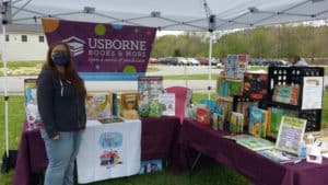 Amber Lesley with her display of Children’s books. Behind her a full parking lot on the opening day of the Chester outdoor market.