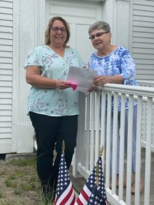Bridget Kelley (left) presenting Co-op Insurance and Greater Falls Insurance gift to Rosemarri Roth (right), Rockingham Meeting House museum senior docent, May 21