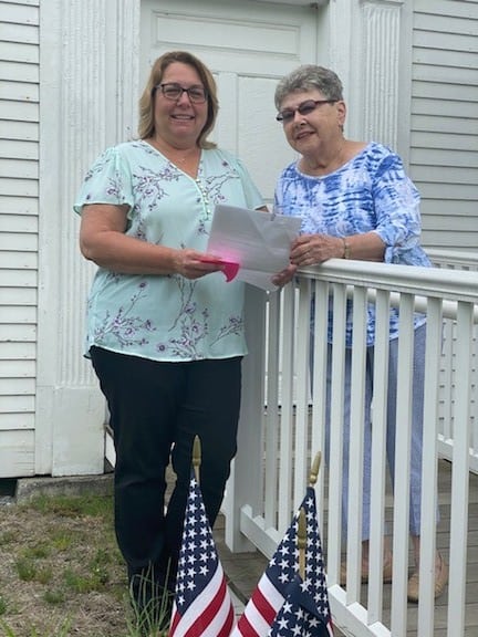 Bridget Kelley (left) presenting Co-op Insurance and Greater Falls Insurance gift to Rosemarri Roth (right), Rockingham Meeting House museum senior docent, May 21