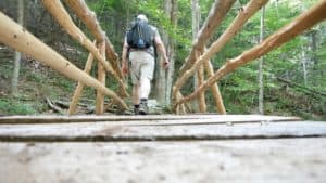 A hiker crosses a mountain stream using one of the newly built bridges on the Norcross Trail. Photo provided by ATA