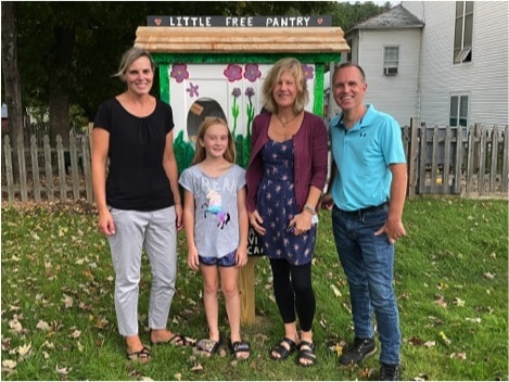 In front of the Saxtons River Little Free Pantry, from left to right: Jaimie Douglass, teacher at Saxtons River Elementary School, Aliyana White from the Saxtons River Elementary Student Council, Berta Martin, and Rob Lauricella, representative of the 24 Main Board.