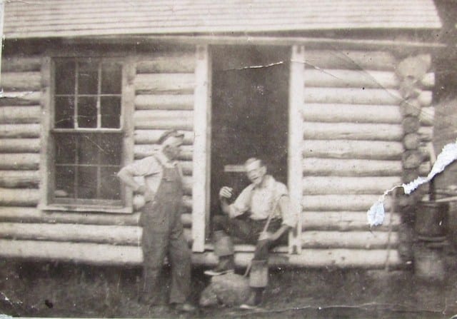 Frank Patch sitting in the doorway of his cabin