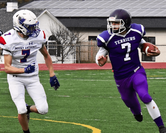 Bellows Falls' quarterback Jon Terry, right, runs the ball, while Mount Anthony's Cole Gino, left, looks to track him down during Saturday's Division II championship game at Alumni Field in Rutland. Photo by Doug MacPhee